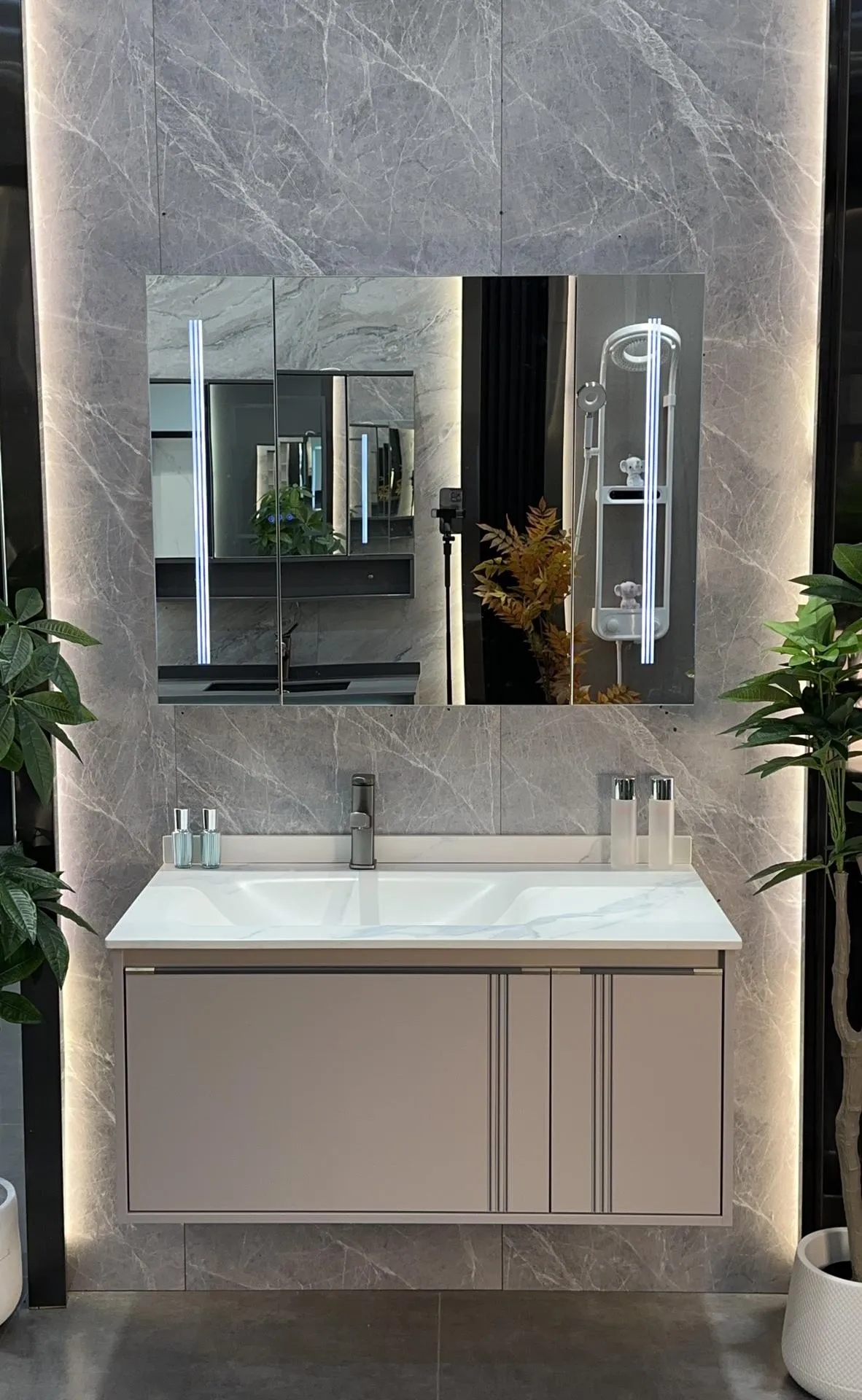 Factory showroom display: sintered stone basin vanity with dark wall-hung cabinet and LED mirror at the Vora Surfaces premises in Foshan.