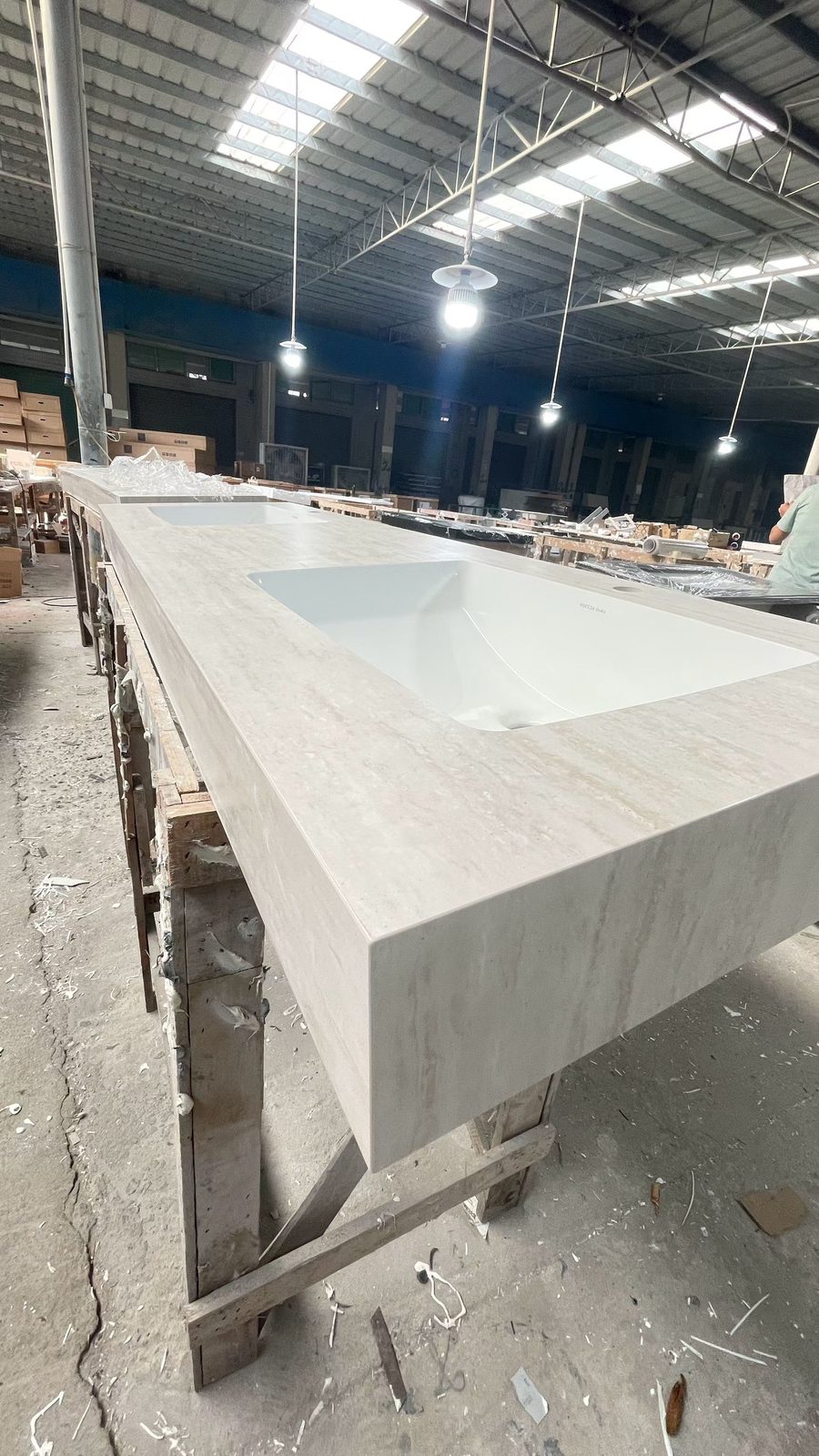 A long sintered stone vanity top with an integrated one-piece basin on the Vora Surfaces factory line